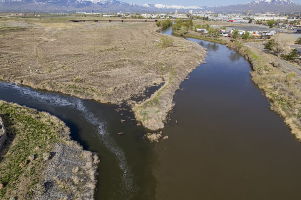 An aerial photograph showing the confluence of Steamboat Creek into the Truckee River, showing a darker brown Truckee compared to the cleaner, clearer Steamboat.