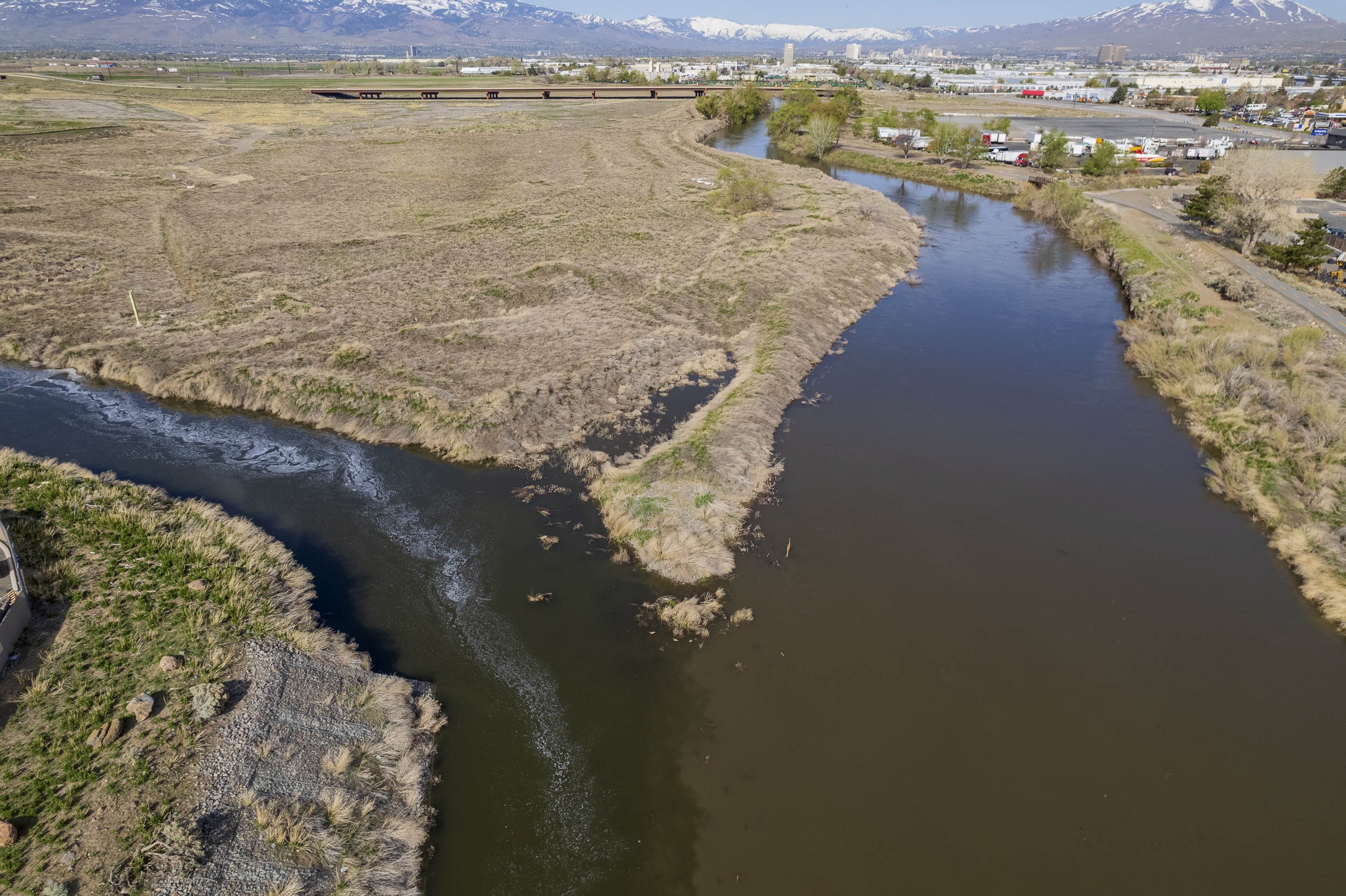 An aerial photograph showing the confluence of Steamboat Creek into the Truckee River, showing a darker brown Truckee compared to the cleaner, clearer Steamboat.