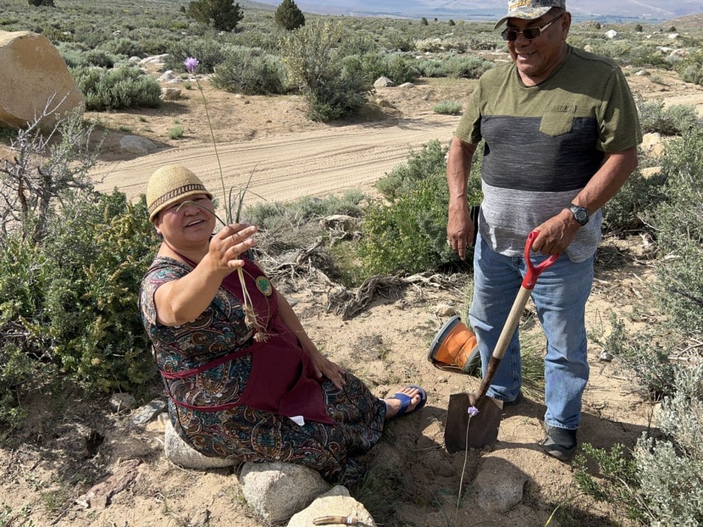 A photo of a woman holding an edible bulb she pulled out of the ground.