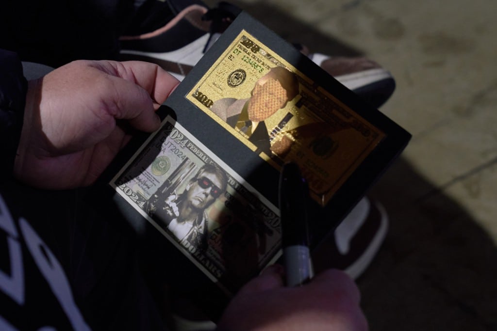 A photo of a person holding Donald Trump memorabilia, money with Trump's face on it.