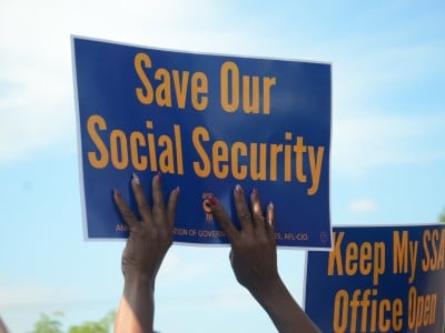 A photo of a person holding a sign that says "Save our Social Security"